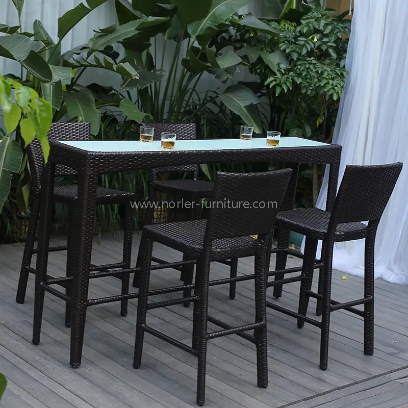 Açıq rattan yüksək bar masa və stullar qoydu